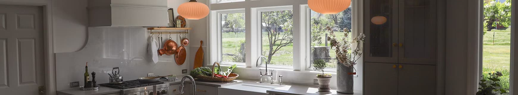 Custom home kitchen with copper pans and a run of windows looking out over open pasture
