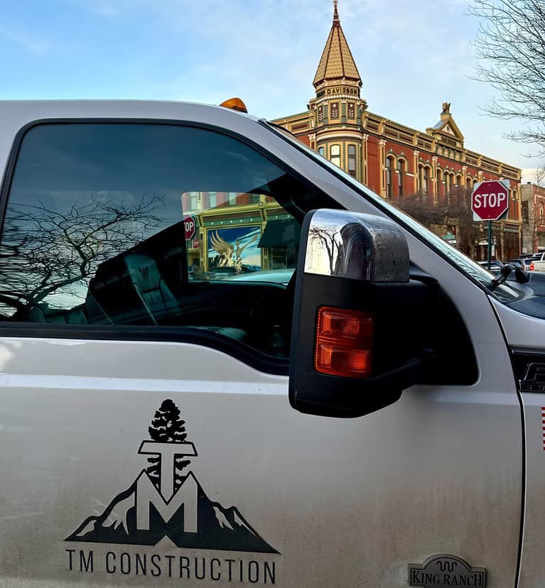 A TM Construction truck parked on a historic downtown Ellensburg street